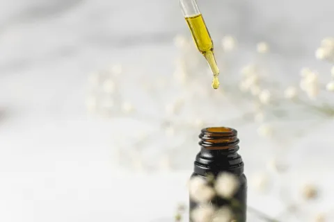 Etherische olie naast een diffuser, geursteen en verdunde roller